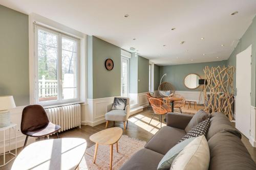a living room with a couch and a table and chairs at BRIT HOTEL & SPA Le Roc au Chien in Bagnoles de l'Orne