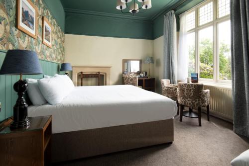 a bedroom with a bed and a desk and a window at The Lakehouse Rooms at The Waterhead Inn, Ambleside in Ambleside