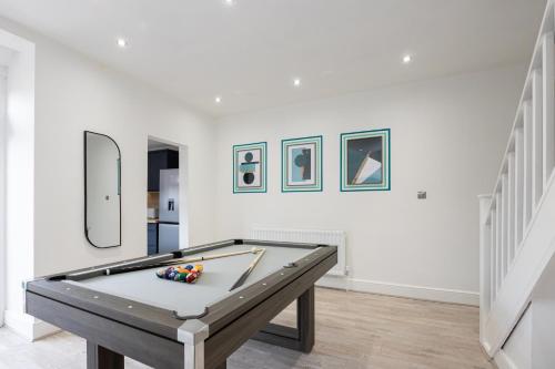 a room with a pool table in a room with paintings at Modern Cozy Home, Cinema & Games Room, Sleeps 8 in Bolton