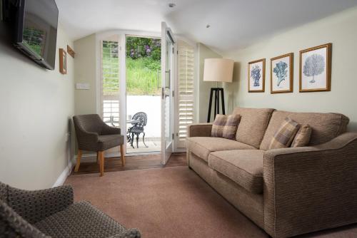 a living room with a couch and a table at The Lakehouse Rooms at The Waterhead Inn, Ambleside in Ambleside
