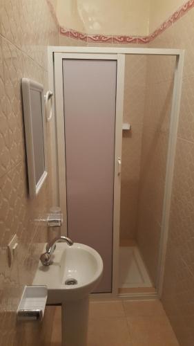 a bathroom with a sink and a shower with a mirror at Maison d'hôtes afoulki tafraout in Tafraoute