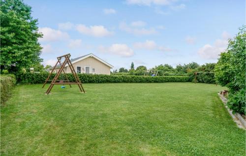 a large yard with a swing set in the grass at Holiday Home Østerbakken Assens Ix in Assens
