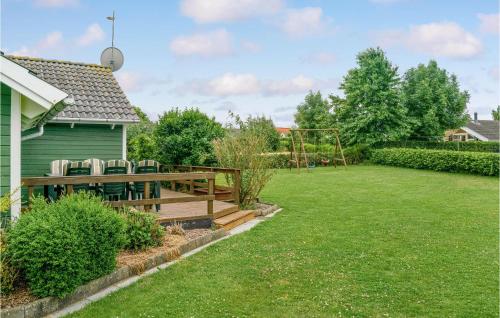 a backyard with a wooden deck and a playground at Holiday Home Østerbakken Assens Ix in Assens