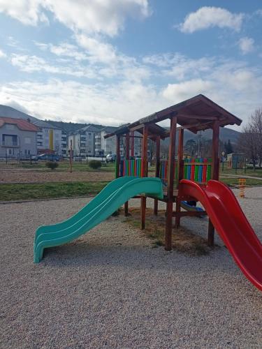 a playground with two slides in a park at OPERA LUX APARTMENTS - Green Hill kompleks Sokobanja & Free Parking - kod Akva Parka in Soko Banja