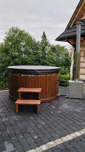 a wooden bench sitting in front of a hot tub at DOMKI NA WIERCHU in Biały Dunajec