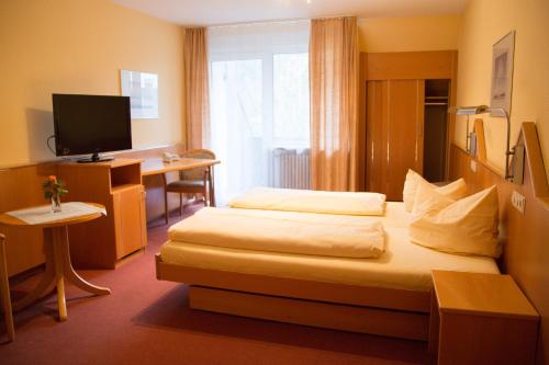 a hotel room with a bed and a desk at Hotel Restaurant Löwen in Zell im Wiesental