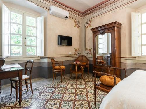 a bedroom with a bed and a table and chairs at PALAZZO CHERCHI in Dorgali