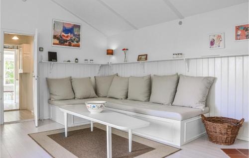 a white couch in a living room with a table at Holiday Home Stængestykket in Udsholt Sand