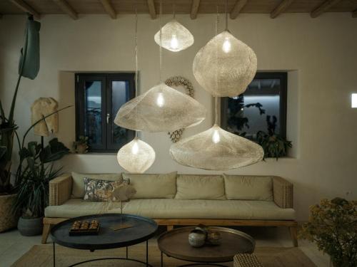 a living room with a couch and several hanging lights at Asty Mykonos Hotel & Spa - World of One Hotel Group in Mýkonos City