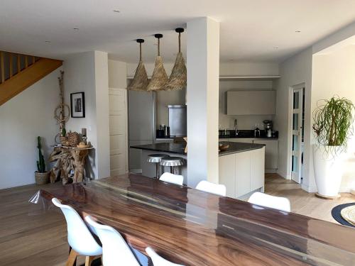une salle à manger et une cuisine avec une table et des chaises blanches dans l'établissement Le Touquet - Villa de vacances proche plage, à Le Touquet-Paris-Plage