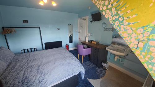 a bedroom with a bed and a desk and a sink at Lagganbeg Guest House in Oban
