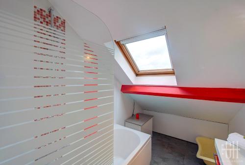 une salle de bain avec une baignoire et une fenêtre dans l'établissement Loéva - Maison de famille, à Tours