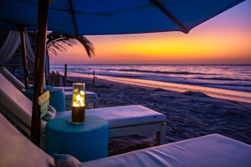 a lit candle sitting on the beach at sunset at DCO Suites Lounge & Spa in Máncora
