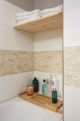 a shelf in a bathroom with bottles and towels at Luxury riverside apartment in Prague