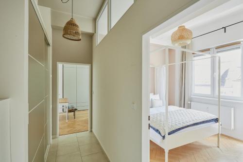a bedroom with a white bed and a window at Luxury riverside apartment in Prague