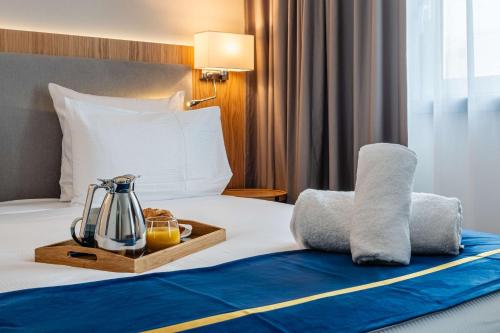 a hotel room with a bed with a tray of food at Brit Hotel Privilège Paris Rosny-sous-Bois in Rosny-sous-Bois
