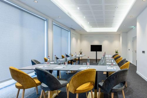 a conference room with a long table and chairs at Brit Hotel Privilège Paris Rosny-sous-Bois in Rosny-sous-Bois