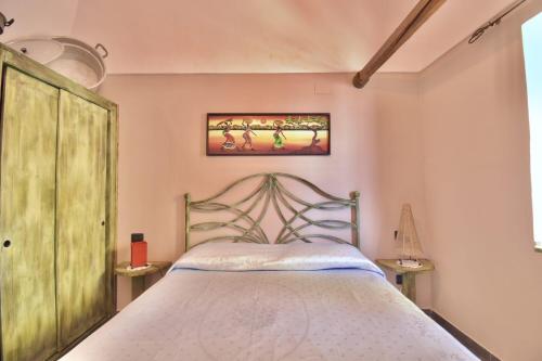 a bedroom with a bed with a wooden head board at Dammuso le Vigne in Pantelleria