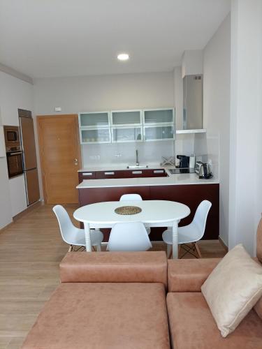 a living room with a couch and a table and a kitchen at Apartamentos Mar y Playa in Moaña