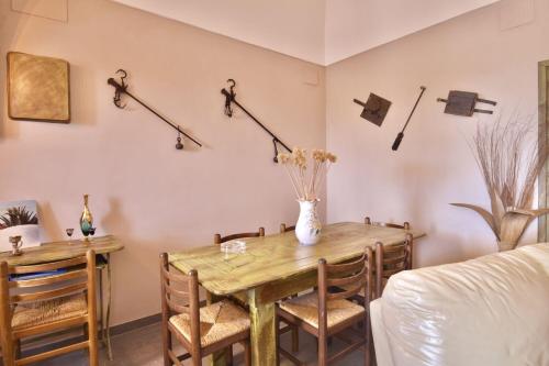 a dining room table with a vase of flowers on the wall at Dammuso le Vigne in Pantelleria