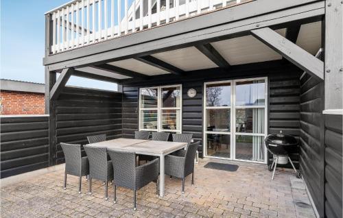a patio with a table and chairs and a grill at Two-Bedroom Holiday Home In Blavand in Blåvand
