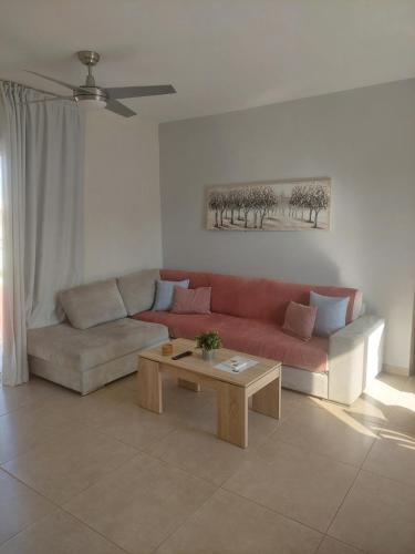 a living room with a red couch and a coffee table at Proteas Mare Suites in Protaras
