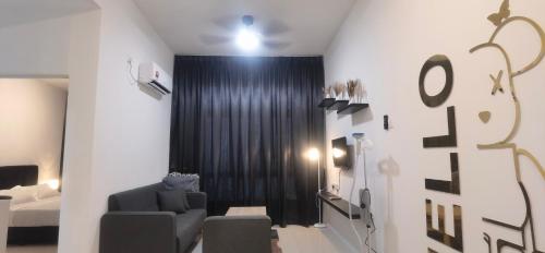 a room with a chair and a bed and a black curtain at Anderson Suite by Hopestay Property Management in Ipoh