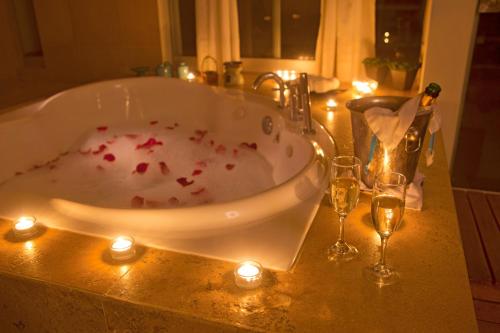 a bath tub with candles and wine glasses on a counter at DCO Suites Lounge & Spa in Máncora