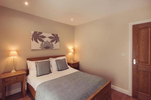 a bedroom with a bed with two night stands and two lamps at Longlands Inn & Cottages in Carnforth