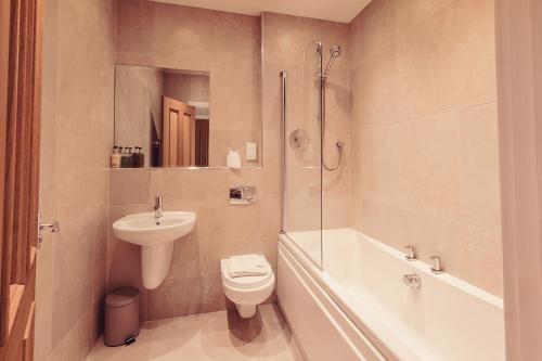 a bathroom with a toilet and a sink and a shower at Longlands Inn & Cottages in Carnforth