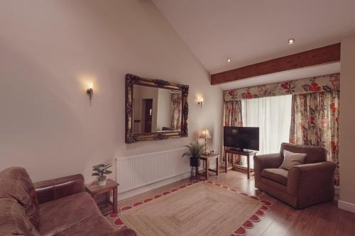 a living room with a couch and a mirror at Longlands Inn & Cottages in Carnforth