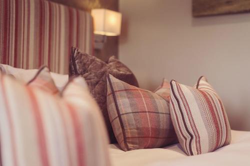 a bunch of pillows sitting on a bed at Longlands Inn & Cottages in Carnforth