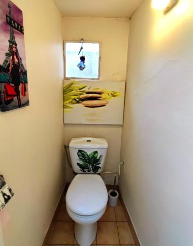 Elle comprend une petite salle de bains pourvue de toilettes et d'une fenêtre. dans l'établissement Maison de vacances avec jardin et parking privés, à Ouistreham