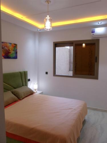 a bedroom with a large bed and a window at Alliance Appart plage -Mehdia in Plage de Mehdia