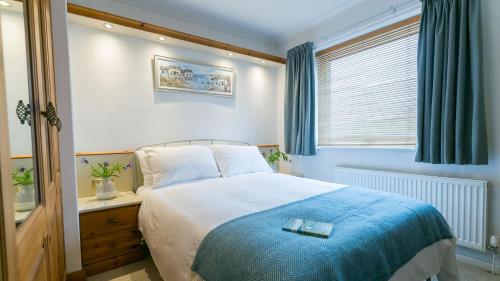 a bedroom with a large bed with a blue blanket at Eryri in Beaumaris