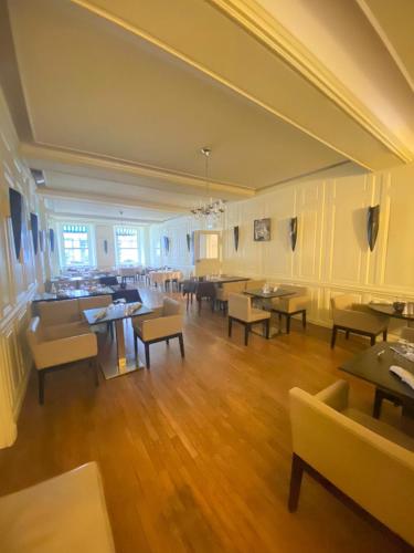 a large room with tables and chairs in a restaurant at Logis Grand Hôtel De L'Europe in Langres