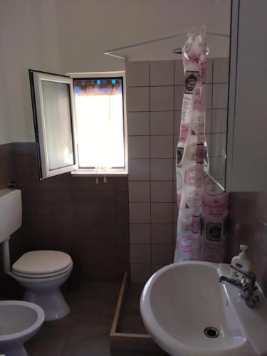 a bathroom with a sink and a toilet and a shower curtain at nuovi appartamenti dai pescatori in Savelletri di Fasano