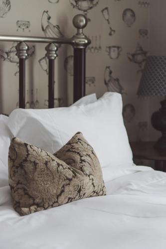 a close up of a bed with white pillows at Longlands Inn & Cottages in Carnforth