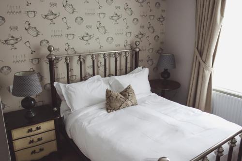 a bedroom with a bed with white sheets and pillows at Longlands Inn & Cottages in Carnforth