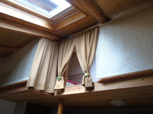 a window in a room with a wooden ceiling at LA CASA DEI NONNI con SPA privata su richiesta in Pont Canavese