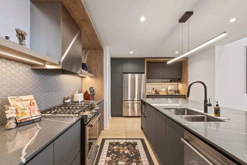 a kitchen with stainless steel appliances and gray cabinets at Tremblant Prestige - Verbier 12-203 in Mont-Tremblant