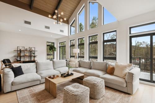 a living room with white furniture and large windows at Tremblant Prestige - Verbier 12-203 in Mont-Tremblant