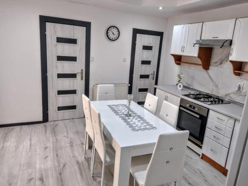 a kitchen with a white table and white chairs at Apartmán Sofia Centrum in Michalovce