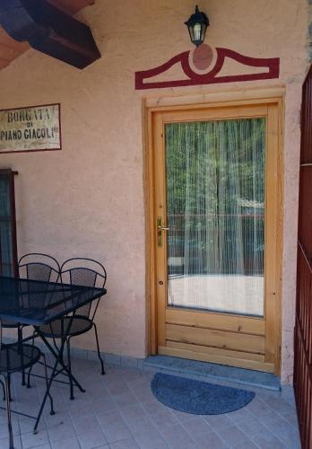 a door to a patio with a table and chairs at LA CASA DEI NONNI con SPA privata su richiesta in Pont Canavese