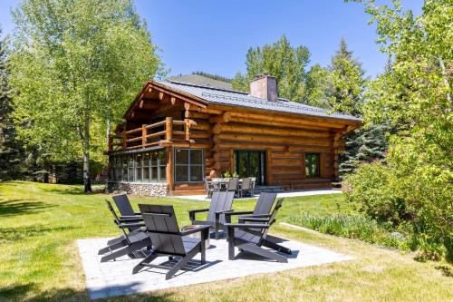 a log cabin with chairs in front of it at The Luxury Cabin at Comfort Circle in Ketchum