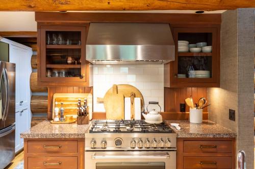 a kitchen with a stove top oven and wooden cabinets at The Luxury Cabin at Comfort Circle in Ketchum
