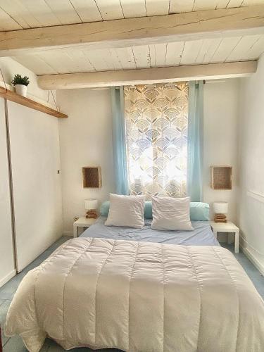 une chambre avec un grand lit et une fenêtre dans l'établissement Jolie villa avec jardin terrasses jacuzzi 15mins plages - MONTPELLIER, à Pignan