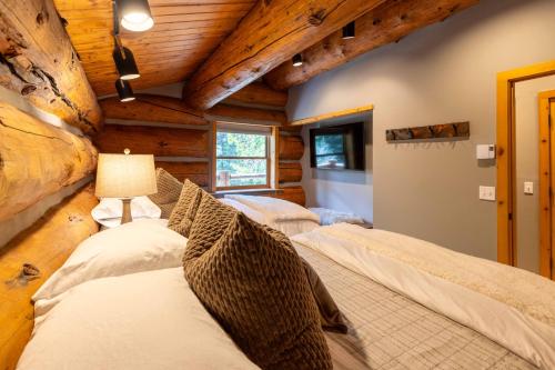 a bedroom with two beds in a log cabin at The Luxury Cabin at Comfort Circle in Ketchum