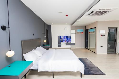 a bedroom with a white bed and a blue table at Bankable Roomzzz in Accra