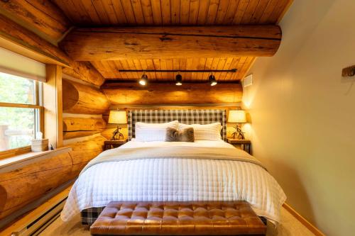 a bedroom with a white bed with a wooden ceiling at The Luxury Cabin at Comfort Circle in Ketchum